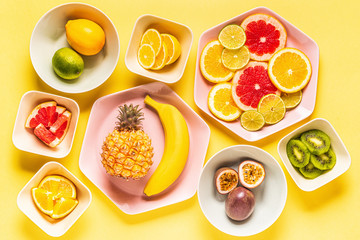 Tropical fruits whole and slices on plates