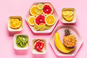 Tropical fruits whole and slices on plates