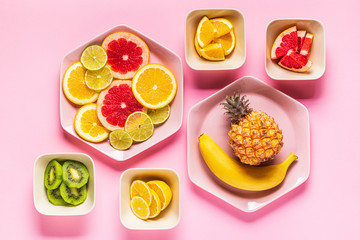 Tropical fruits whole and slices on plates