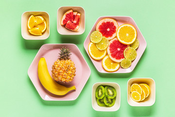 Tropical fruits whole and slices on plates