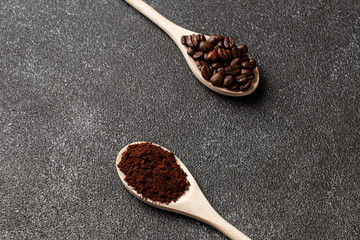 Coffee beans on wooden spoon. Dark concrete. Top view. Empty space.