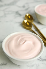 Tasty organic yogurt on white marble table