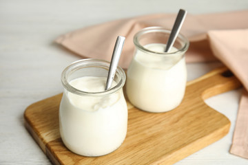Tasty organic yogurt on white wooden table