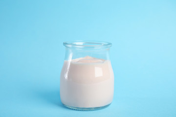 Tasty organic yogurt on light blue background
