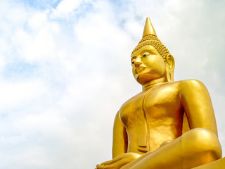 Fototapeta premium The large golden Buddha image stands majestically against the sky in the background.