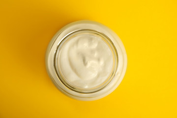 Tasty organic yogurt on yellow background, top view