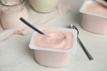 Tasty organic yogurt on white wooden table