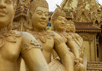 entrance of a buddhist temple in aisa with golden statues 