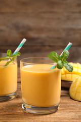 Fototapeta premium Fresh delicious mango drink on wooden table