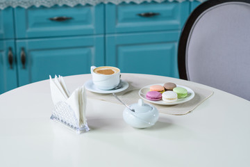 Delicious cappuccino and macaroons prepared on a table for a guest