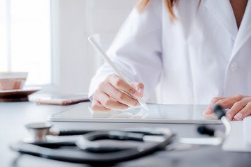 Closeup of female doctor using digital tablet at hospital.