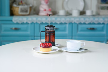 Delicious berry tea and tarte with raspberries on a table in a cozy coffee shop