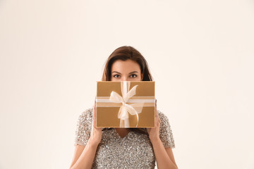 Beautiful woman with Christmas gift on white background