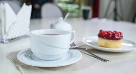 Delicious berry tea and tarte with raspberries prepared on a table for a guest in a cozy cafe