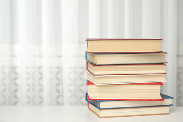 Collection of different books on table indoors. Space for text