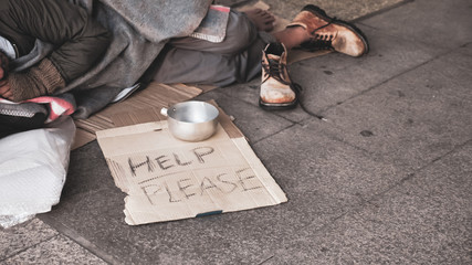 Homeless man sleeping on outdoor floor.