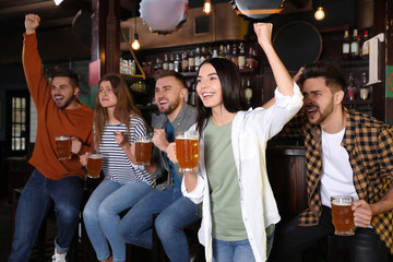 Fototapeta premium Group of friends watching football in sport bar