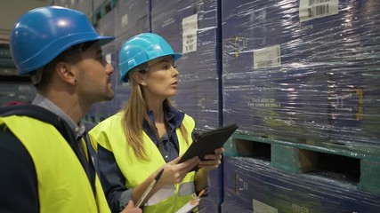 Workers in warehouse controlling incoming merchandise