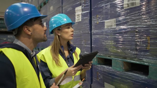 Workers in warehouse controlling incoming merchandise