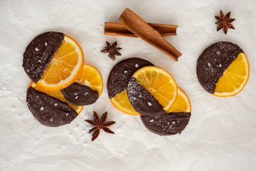 Candied orange in chocolate is a favorite Christmas treat for children and adults. Image of homemade candied orange dipped in chocolate. Top view
