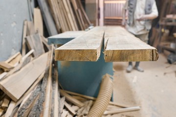 Male carpenter working on circular machine in workshop