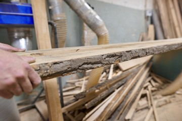 Carpenters hands with plank wood at carpentry woodworking workshop