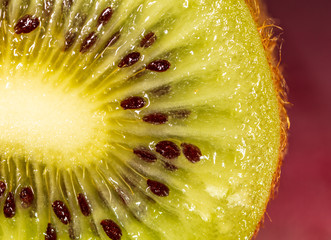 Seeds on a sliced green kiwi as a background
