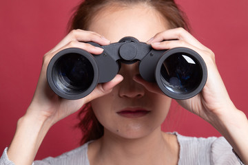 Young Asian woman with binoculars.