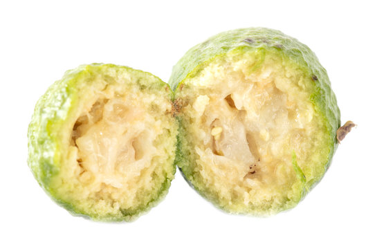The cut feijoa is isolated on a white background
