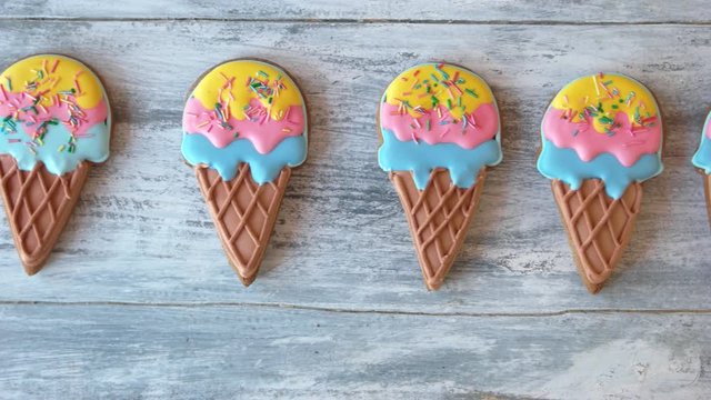 Row of cookies shaped as ice cream. Set of colorful biscuits on gray wooden background. Snacks for kids birthday party.