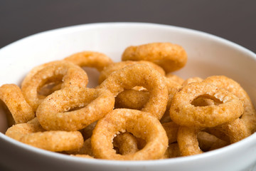 Fried onion snacks in white bowl. 