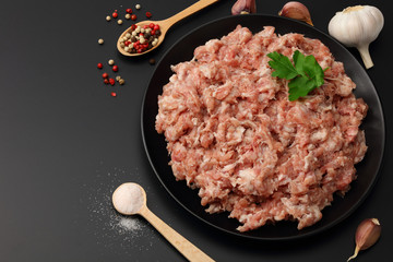 Mince. Ground meat with spices on black background. Top view