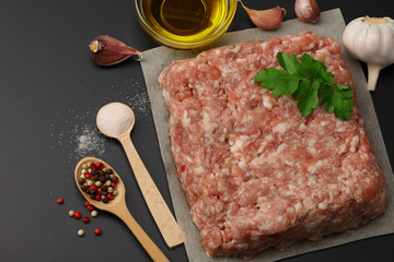 Mince. Ground meat with spices on black background. Top view