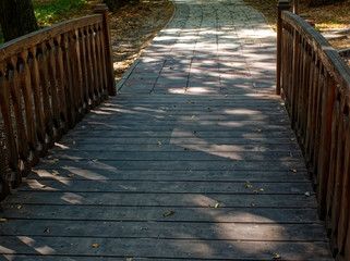 Fototapeta premium shadows from trees on a wooden bridge, Moscow.