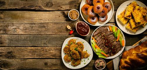 Selection of traditional hanukkah food for festive dinner - Potato Latkes, Applesauce, Challah,...