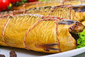 Smoked fish on plate close up, golden mackerel