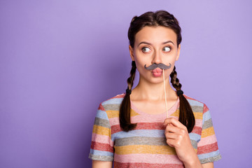 Photo of funny childish lady holding fake paper moustache mouth acting like guy masquerade party...