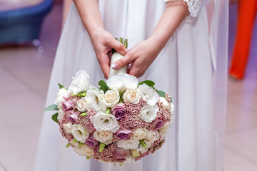 Obraz na płótnie Canvas A wedding bouquet in hands of the bride