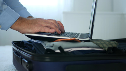 Businessman Using Laptop on a Suitcase Open Screen and Check Emails and Messages