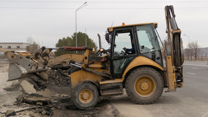 Backhoe loader working on the road.