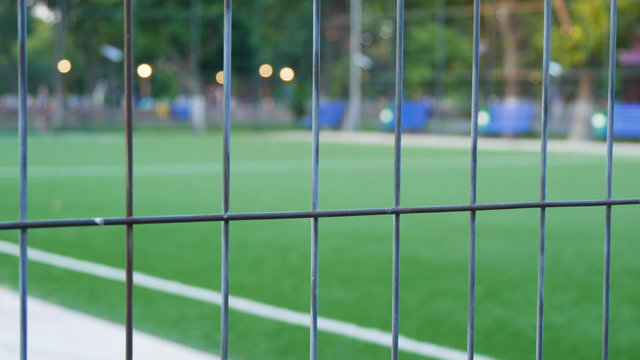Image with a Football Field Protected by a Metallic Fence