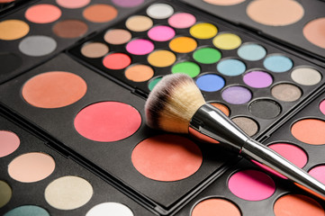 Decorative cosmetics for eye makeup, pallets with bright colors and cosmetic drawing brush