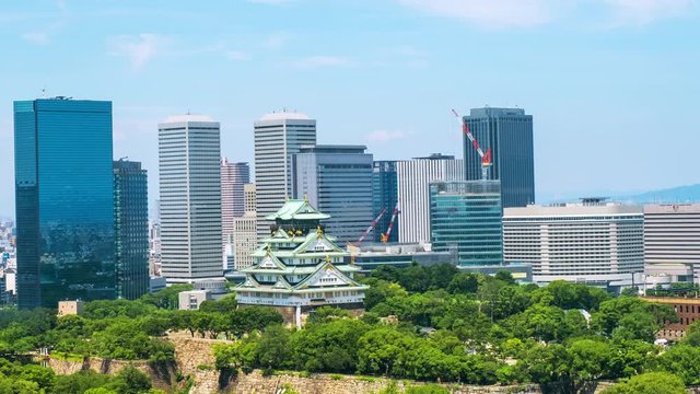 Osaka, Japam. Aerial view of Castle Park in Osaka, Japan with modern skyscrapers at the background. Time-lapse of moving clouds during the hot day with car and people traffic , panning video