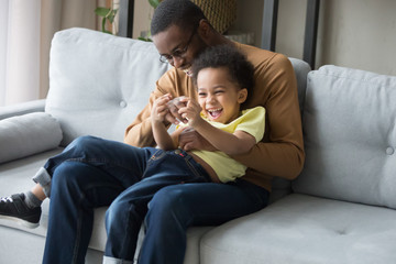 Happy black father and son have fun at home