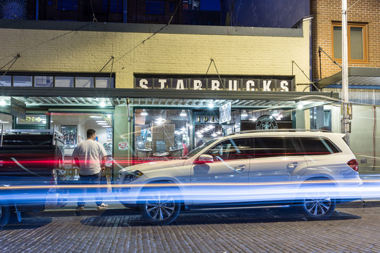 Seattle, Washington, USA - March 1, 2015_Nightlife at the original Starbucks store, The first Starbucks coffee store at Pike Place Public Market in Seattle, established in 1971, illustrative editorial