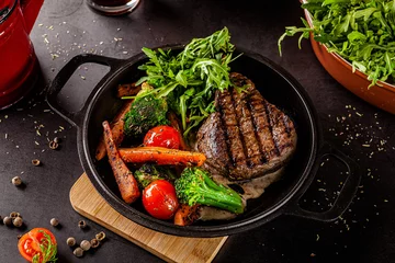 Papier Peint photo Manger Concept de cuisine américaine. Steak de bœuf grillé aux légumes grillés, avec carottes, tomates cerises, brocolis, dans une poêle en fonte. copie espace