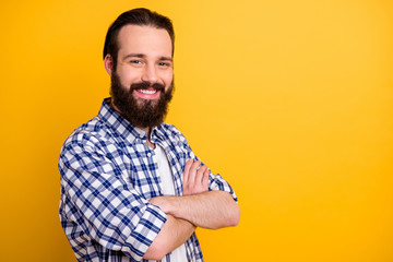 Close-up profile side view portrait of his he nice attractive cheerful bearded guy in checked shirt folded arms skilled IT professional isolated over bright vivid shine vibrant yellow color background