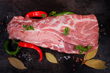 Top view of uncooked pork neck among vegetables and spices