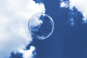 a soap bubble flies against the sky with clouds, close-up, Repainted and tone in a modern color, the classic blue Pantone trend color 2020.