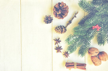 Christmas composition. Fresh fir tree branches, red berries, pine cones, anise, cinnamon and nuts on vintage background. Christmas, winter, new year concept. Flat lay, top view, copy space.